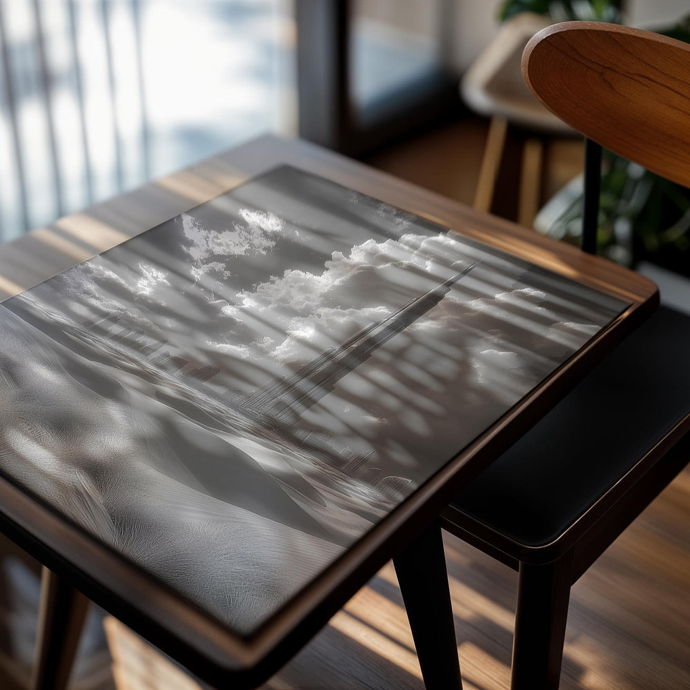 Black and white image of a tall tower with clouds and landscape, as a premium aluminum metal print from GoMetalPrint.
