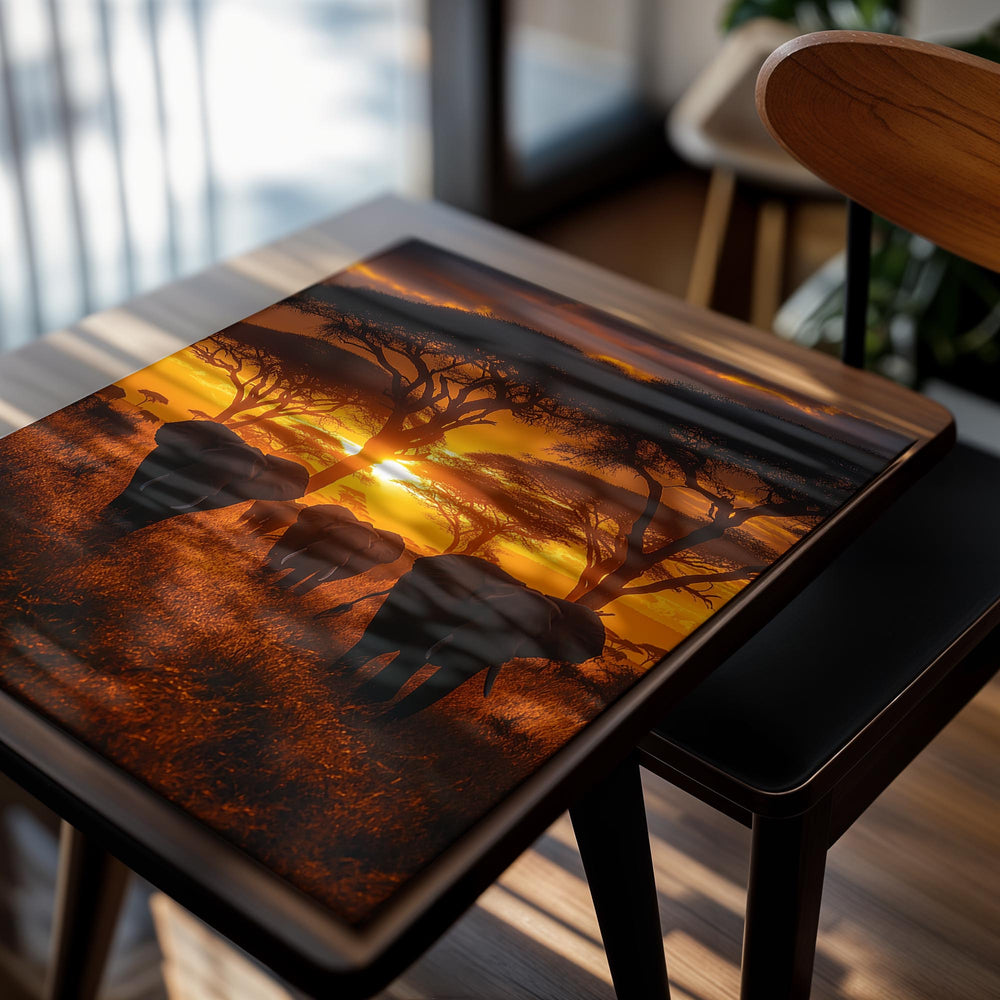 Elephants walking through a grassy field with acacia trees at sunset, as a premium aluminum metal print from GoMetalPrint.
